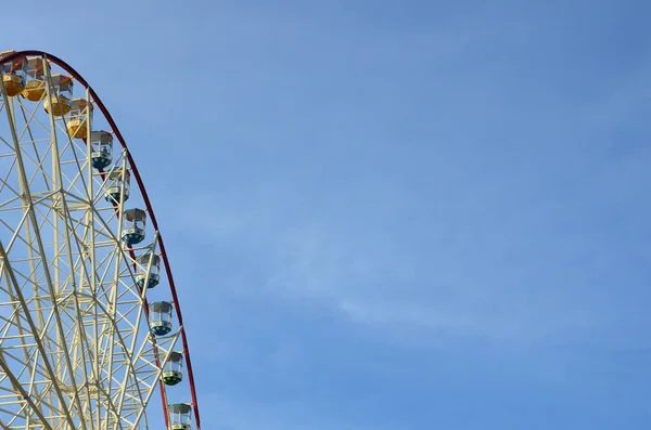 Entertainment Ferris wheel against the clear blue sky in sunny day