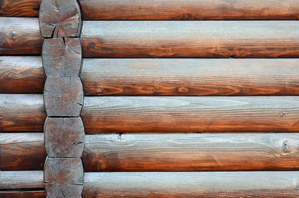 Hewn timber. Rustic log wall horizontal timber background. Fragment of unpainted wooden debarked logs. House wall wallpaper texture