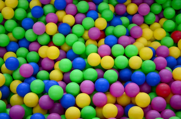 Colored plastic balls in pool of game room. Swimming pool for fun and jumping in colored plastic balls