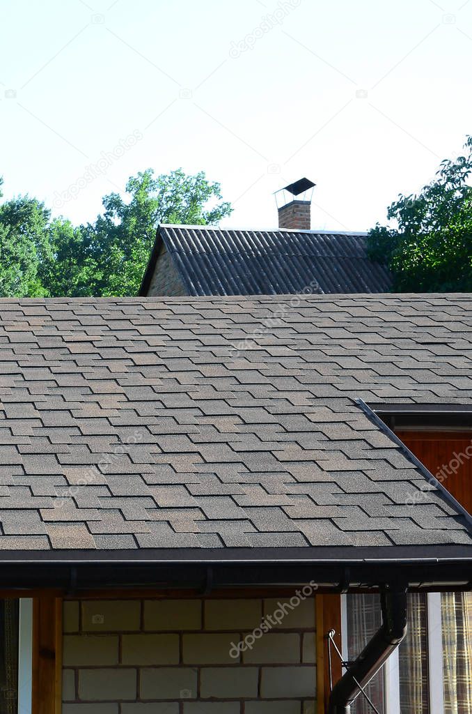 Modern roofing and decoration of chimneys. Flexible bitumen or slate shingles in rectangular shape in perspective.