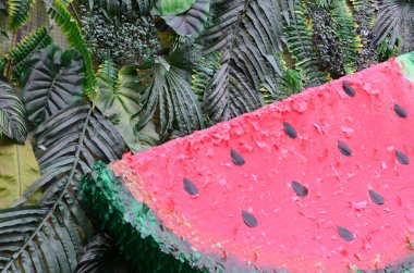 Tropikal desen orman yaprakları ve karpuz meyve çiçek arka plan ile. Plastik karpuz dilimi palmiye yaprağı