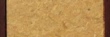 OSB tahtaları ahşap bir zemine zımparalanmış kahverengi odun parçalarından yapılmıştır. OSB ahşap kaplama arka planının üst görünümü, sıkı, pürüzsüz yüzeyler