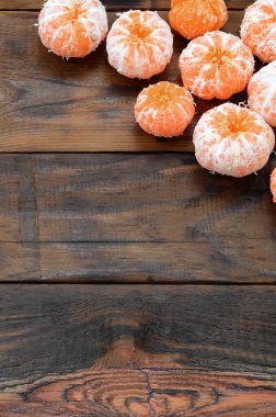 Bir sürü taze portakal mandalina yalan kahverengi ahşap arka plan üzerinde. Meyve mezarda düz yatırın