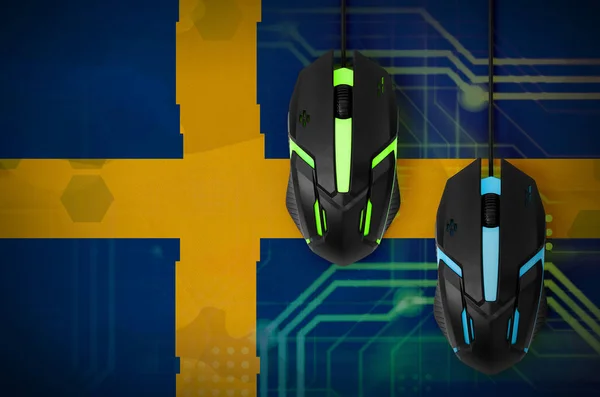 Sweden flag  and two modern computer mice with backlight. The concept of online cooperative games. Cyber sport team