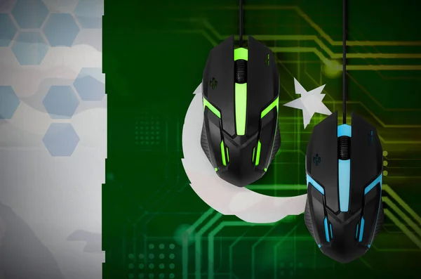 Pakistan flag  and two modern computer mice with backlight. The concept of online cooperative games. Cyber sport team