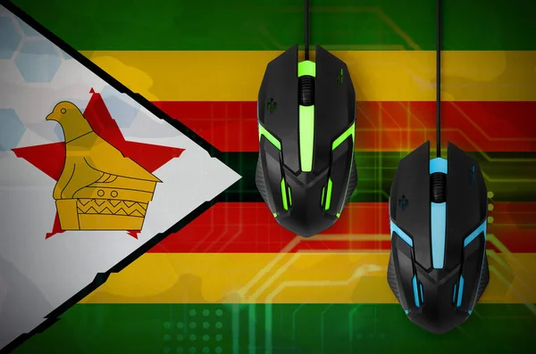 Zimbabwe flag  and two modern computer mice with backlight. The concept of online cooperative games. Cyber sport team