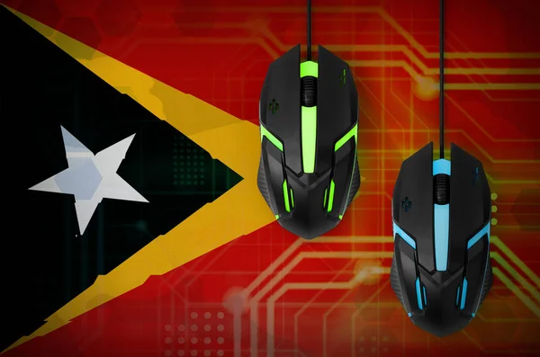 Timor Leste flag  and two modern computer mice with backlight. The concept of online cooperative games. Cyber sport team