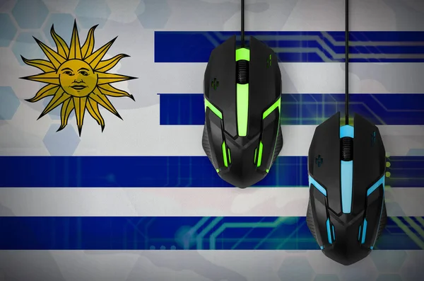 Uruguay flag  and two modern computer mice with backlight. The concept of online cooperative games. Cyber sport team
