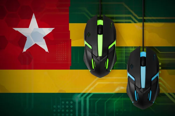 Togo flag  and two modern computer mice with backlight. The concept of online cooperative games. Cyber sport team