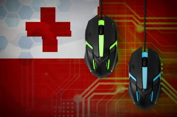 Tonga flag  and two modern computer mice with backlight. The concept of online cooperative games. Cyber sport team