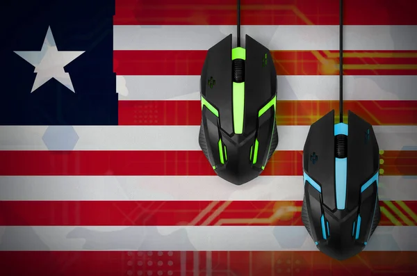 Liberia flag  and two modern computer mice with backlight. The concept of online cooperative games. Cyber sport team