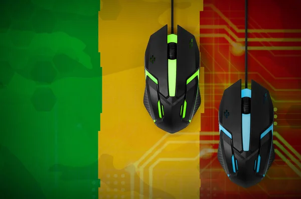 Mali flag  and two modern computer mice with backlight. The concept of online cooperative games. Cyber sport team