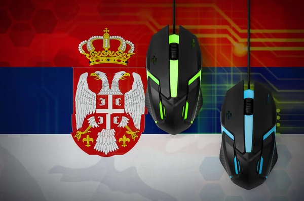 Serbia flag  and two modern computer mice with backlight. The concept of online cooperative games. Cyber sport team
