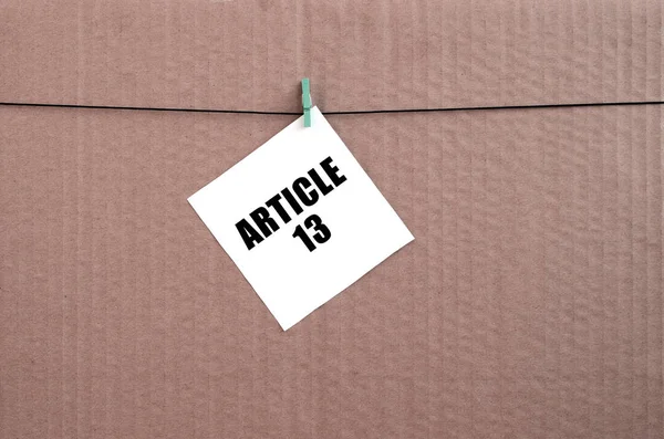 Άρθρο 13 επιγραφή σε λευκή κάρτα σε σχοινί σε ένα καφέ χαρτόνι υπόβαθρο — Φωτογραφία Αρχείου