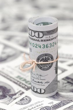 Bize dolar haddelenmiş ve grup ile sıkılaştırılmış bir sürü Amerikan banknotları bulanık arka plan ile yatıyor. Para büyük miktarda