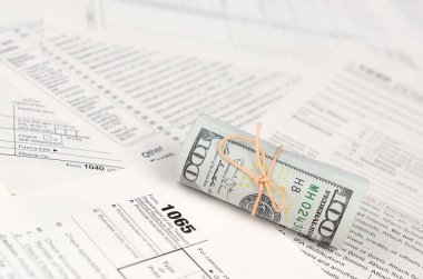 1065 Amerikan doları banknotları ile Amerika Birleşik Devletleri geri dönüş gelir formunu kaplayın. ABD 'de vergi dönemi kavramı
