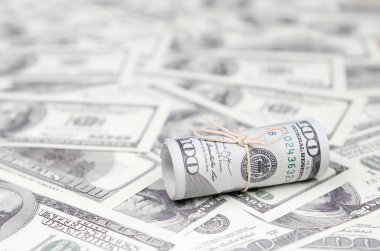 Bize dolar haddelenmiş ve grup ile sıkılaştırılmış bir sürü Amerikan banknotları bulanık arka plan ile yatıyor. Para büyük miktarda