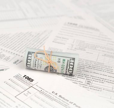 1065 Amerikan doları banknotları ile Amerika Birleşik Devletleri geri dönüş gelir formunu kaplayın. ABD 'de vergi dönemi kavramı