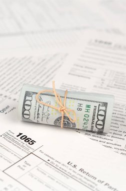 1065 Amerikan doları banknotları ile Amerika Birleşik Devletleri geri dönüş gelir formunu kaplayın. ABD 'de vergi dönemi kavramı