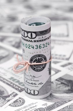 Bize dolar haddelenmiş ve grup ile sıkılaştırılmış bir sürü Amerikan banknotları bulanık arka plan ile yatıyor. Para büyük miktarda