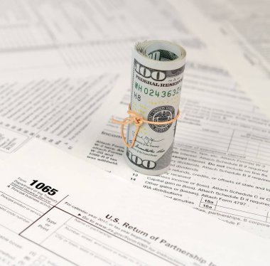 1065 Amerikan doları banknotları ile Amerika Birleşik Devletleri geri dönüş gelir formunu kaplayın. ABD 'de vergi dönemi kavramı