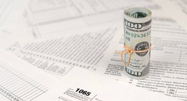 1065 Amerikan doları banknotları ile Amerika Birleşik Devletleri geri dönüş gelir formunu kaplayın. ABD 'de vergi dönemi kavramı
