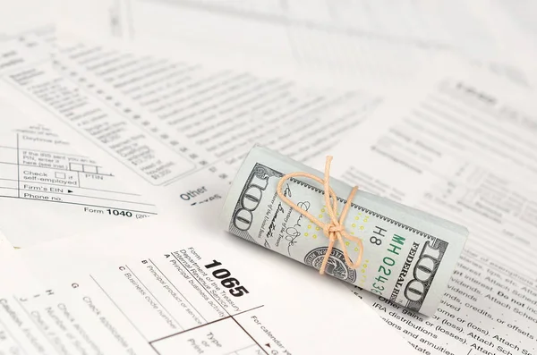 1065 Amerikan doları banknotları ile Amerika Birleşik Devletleri geri dönüş gelir formunu kaplayın. ABD 'de vergi dönemi kavramı