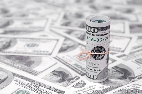 Bize dolar haddelenmiş ve grup ile sıkılaştırılmış bir sürü Amerikan banknotları bulanık arka plan ile yatıyor. Para büyük miktarda