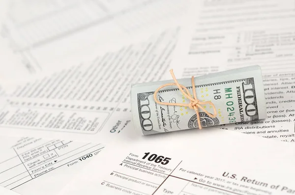 1065 Amerikan doları banknotları ile Amerika Birleşik Devletleri geri dönüş gelir formunu kaplayın. ABD 'de vergi dönemi kavramı