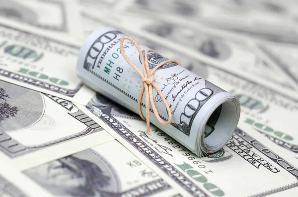 Bize dolar haddelenmiş ve grup ile sıkılaştırılmış bir sürü Amerikan banknotları bulanık arka plan ile yatıyor. Para büyük miktarda