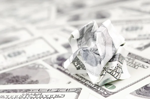 Crumpled dollar bill of the United States lies on the set of smooth money bills. Concept of unreasonable waste of money