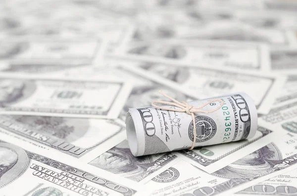 Bize dolar haddelenmiş ve grup ile sıkılaştırılmış bir sürü Amerikan banknotları bulanık arka plan ile yatıyor. Para büyük miktarda