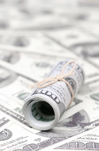 Bize dolar haddelenmiş ve grup ile sıkılaştırılmış bir sürü Amerikan banknotları bulanık arka plan ile yatıyor. Para büyük miktarda