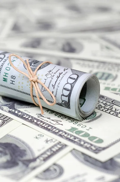 Bize dolar haddelenmiş ve grup ile sıkılaştırılmış bir sürü Amerikan banknotları bulanık arka plan ile yatıyor. Para büyük miktarda