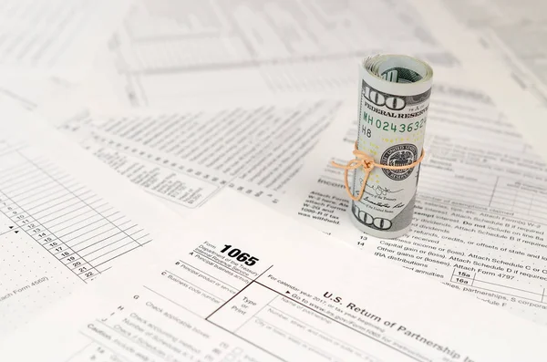 1065 Amerikan doları banknotları ile Amerika Birleşik Devletleri geri dönüş gelir formunu kaplayın. ABD 'de vergi dönemi kavramı