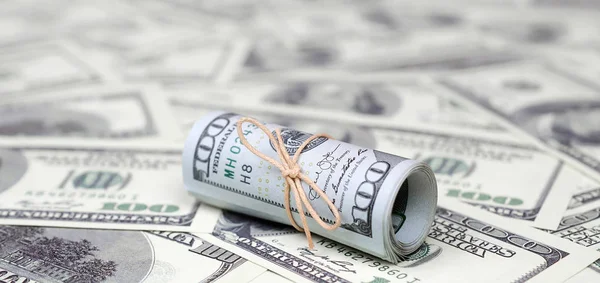 Bize dolar haddelenmiş ve grup ile sıkılaştırılmış bir sürü Amerikan banknotları bulanık arka plan ile yatıyor. Para büyük miktarda