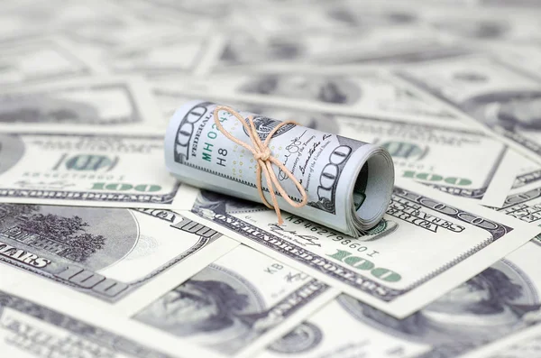 Bize dolar haddelenmiş ve grup ile sıkılaştırılmış bir sürü Amerikan banknotları bulanık arka plan ile yatıyor. Para büyük miktarda