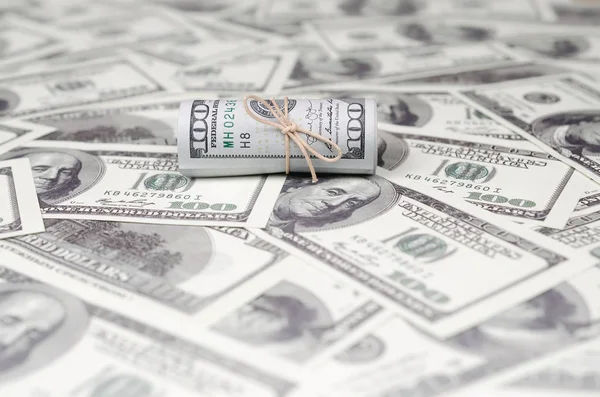 Bize dolar haddelenmiş ve grup ile sıkılaştırılmış bir sürü Amerikan banknotları bulanık arka plan ile yatıyor. Para büyük miktarda