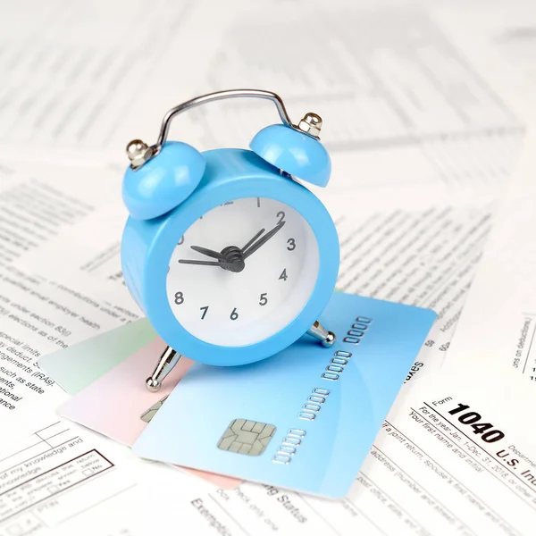 1040クレジットカードの青い目覚まし時計と個人所得税申告フォーム アメリカ合衆国における税期間の概念 — ストック写真