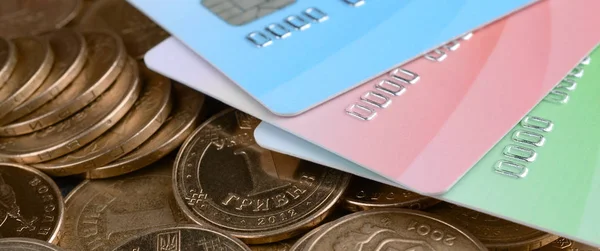 Oekraïense geld munten en gekleurde creditcards close up — Stockfoto