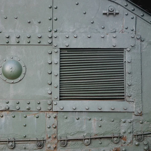 Textura de la pared lateral del tanque, hecha de metal y reforzada con una multitud de pernos y remaches — Foto de Stock