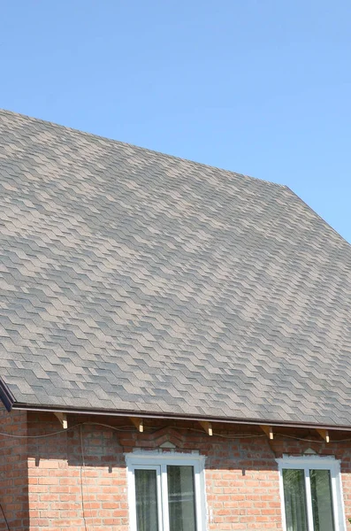 Telhas flexíveis de superfície de cobertura de betume na casa de tijolos — Fotografia de Stock