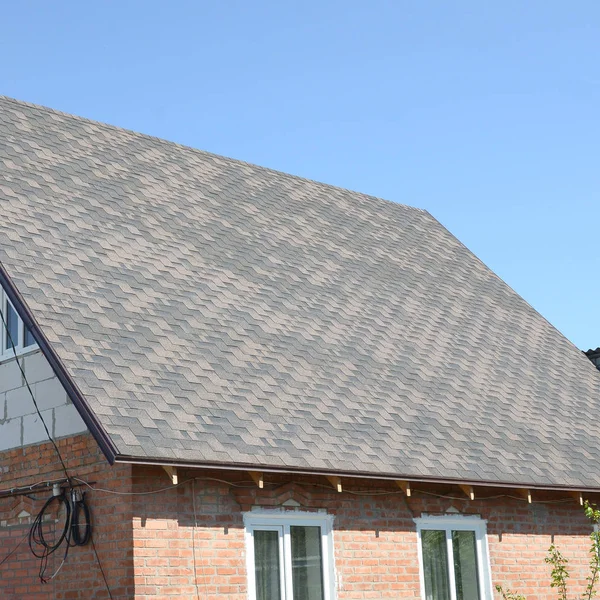 Bardeaux flexibles de surface de toiture de bitume sur la maison de brique — Photo