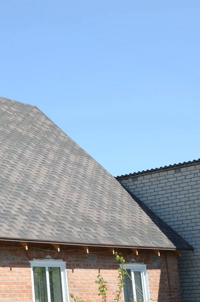 Bardeaux flexibles de surface de toiture de bitume sur la maison de brique — Photo