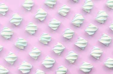 Renkli marshmallow pembe kağıt arka plan üzerine serilmiş