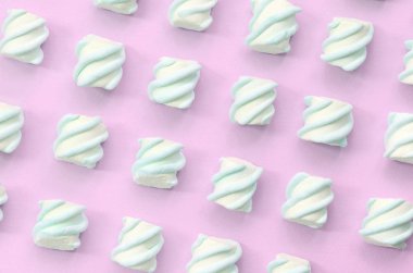 Renkli marshmallow pembe kağıt arka plan üzerine serilmiş