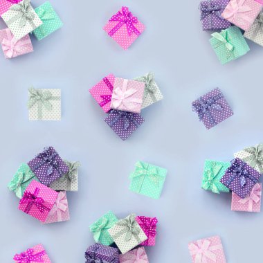 Kurdeleler ile küçük renkli hediye kutuları yığınları bir mor arka plan üzerinde yatıyor