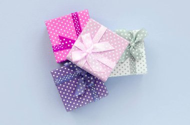 Kurdeleler ile küçük renkli hediye kutuları Yığını bir mor arka plan üzerinde yatıyor