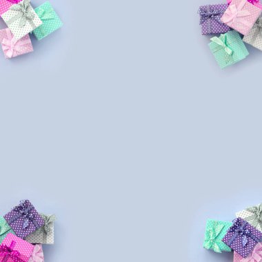 Kurdeleler ile küçük renkli hediye kutuları yığınları bir mor arka plan üzerinde yatıyor