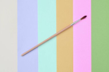 Yeni bir boya fırçası moda pastel pembe doku arka plan üzerinde yalan, mavi, yeşil, sarı, mor ve bej renkler kağıt